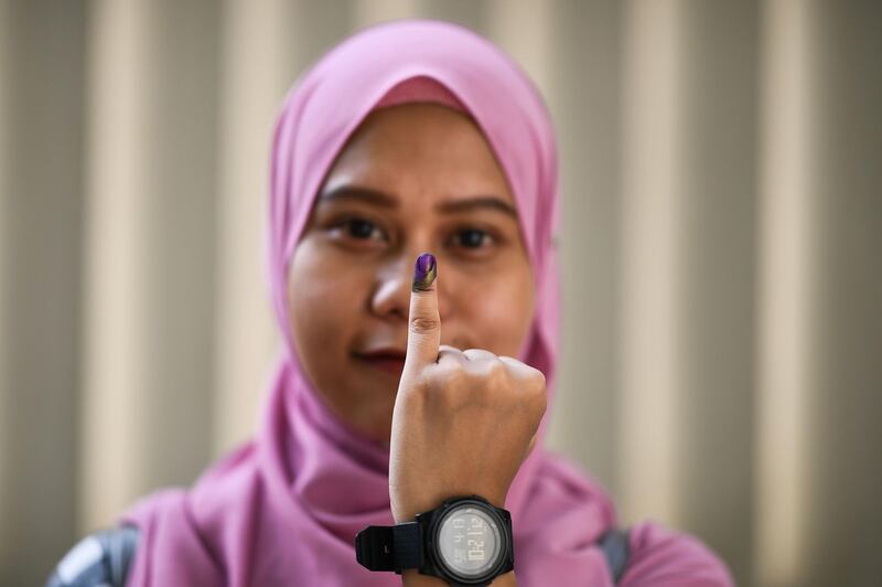 An Indonesian woman, living in Malaysia, shows her inked finger after casting her overseas ballot ahead of the country's April 17 general election, in Kuala Lumpur on April 14, 2019. AFP