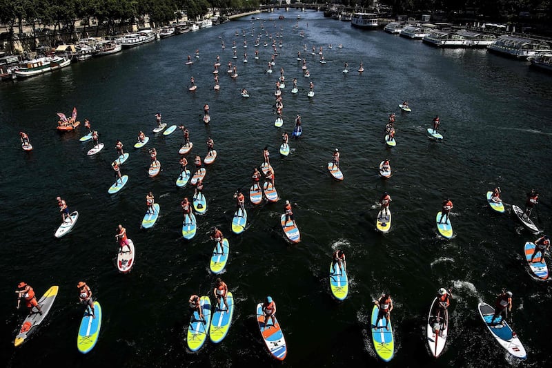 Participants compete in a stand-up paddle rally organised by the National Society of Sea Rescue (SNSM) on the Seine river in Paris during the national day of of the Sea Rescuers.  AFP