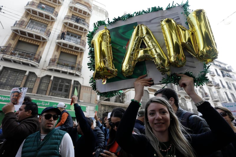 A woman carries a banner as thousands of Algerians take to the street to commemorate the first anniversary of the popular protests in Algiers, Algeria. AP Photo