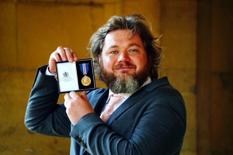 Lukasz Koczocik shows off his Queen's Gallantry Medal after an investiture ceremony at Windsor Castle. Getty Images