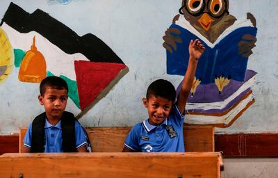 TOPSHOT - Palestinian students attend a class at a school run by the United Nations Relief and Works Agency (UNRWA) in Jabalia refugee camp in northern Gaza Strip,  on the first day of school after local authorities eased some of the restrictions that were imposed in a bid to slow the spread of the novel coronavirus, on August 8, 2020.   / AFP / MAHMUD HAMS
