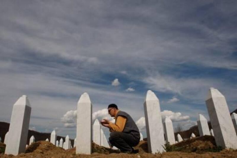 Bosnian Muslim man says a prayer in front of the grave stone of his relative at Memorial Center of Potocari, near Srebrenica, 70 kms norteast of Bosnian capital of Sarajevo, on Thursday April 1, 2010.  Serbia's parliament has apologized to the Bosnian Muslim victims of the 1995 Srebrenica massacre Wednesday, ending years of denial, a move which is being seen as a crucial part for reconciliation in the war-scarred Balkans. (AP Photo/Amel Emric) *** Local Caption ***  XAE107_BOSNIA_SREBRENICA_SRBIJA_APOLOGIZE.jpg