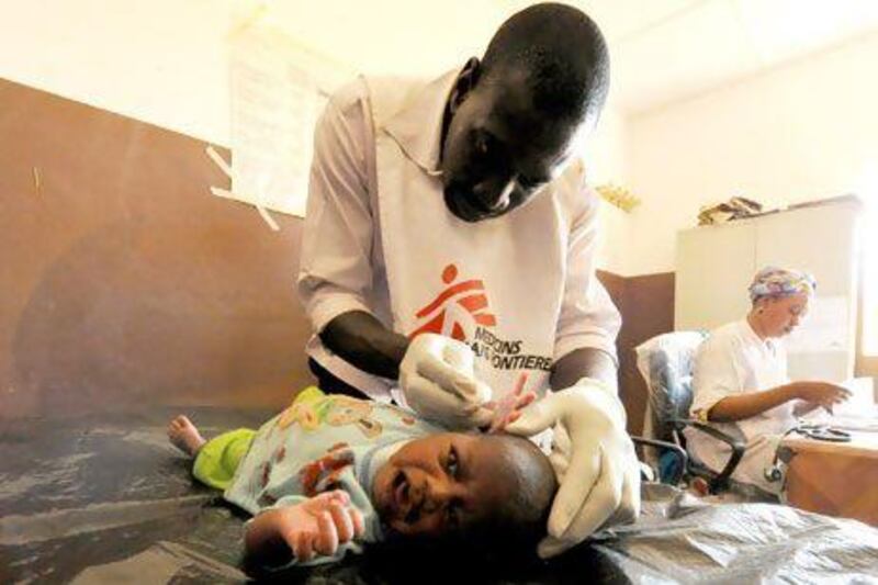 A worker from Medecins Sands Frontieres examines a sick baby in Gao, in the north of Mali. Sia Kambou / AFP