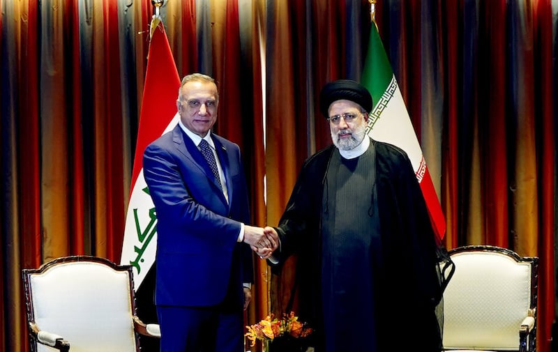 Mr Al Kadhimi greets Iran's President Ebrahim Raisi. 