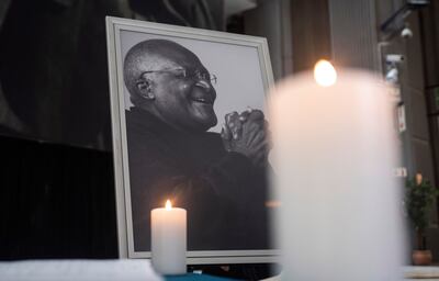 Candles are lit in front of a photograph of the late Archbishop Emeritus Desmond Tutu at the Cape Town civil centre, Cape Town, South Africa, 26 December 2021.  EPA