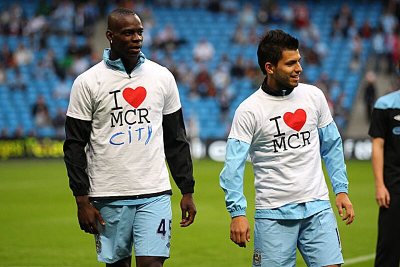 Unused substitute Mario Balotelli, left, makes sure fans know he loves Manchester City, rather than the rock band My Chemical Romance along with City's two-goal hero Sergio Aguero.
 
Alex Livesey / Getty Images