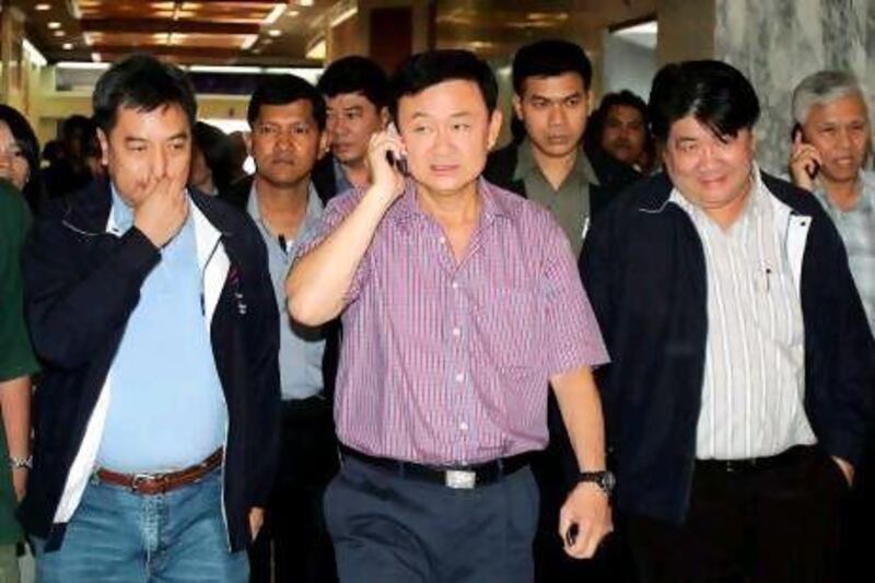 Thaksin Shinawatra, centre, having made his fortune from telecommunications, is revealed in Tom Plate's Giants of Asia series, to have a dozen mobile phones on the go at any given moment. Saeed Khan / AFP