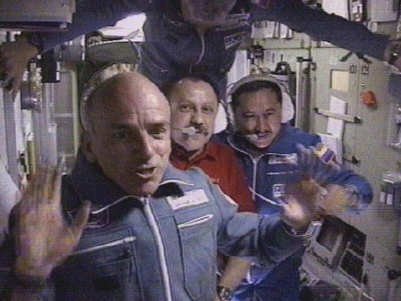 388502 03: The worlds first space tourist Dennis Tito waves in front of the International Space Station crew shortly after his arrival to the station April 30, 2001 in this image from television. In the background are space station commander Yuri Usachev, center, bottom, Russian cosmonauts Talgat Musabayev, right, and Yuri Baturin, center, top. Tito is paying as much as $20 million for this adventure of a lifetime. (Photo by RTV/Oleg Nakishin/Newsmakers