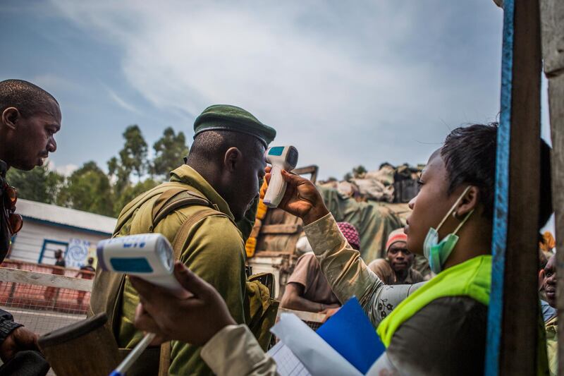 A Congolese wildlife ranger is screened by a health worker for Ebola symptoms at a checkpoint set up on the road connecting Butembo and Goma. EPA