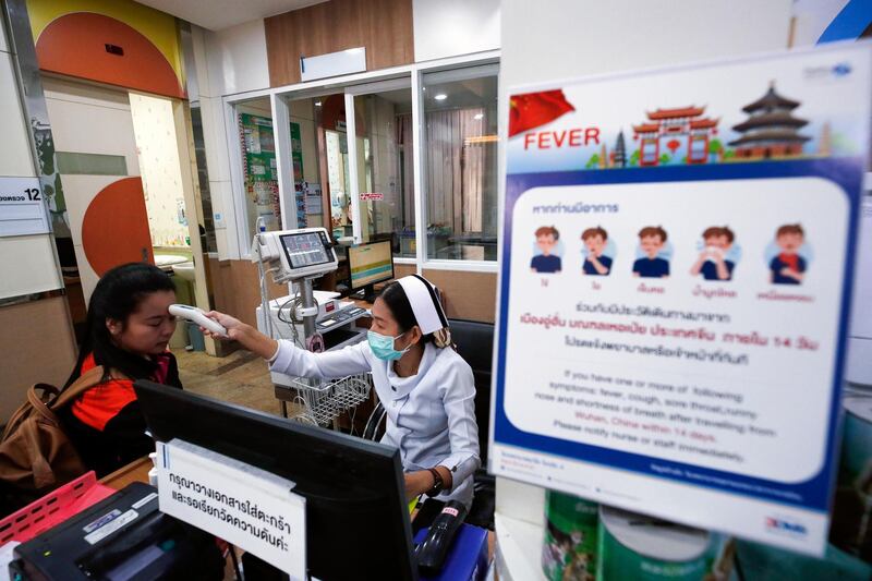 epa08149815 A nurse checks a patient's body temperature next to a campaign poster alerting on the coronavirus at a hospital in Bangkok, Thailand, 22 January 2020. The SARS-like coronavirus was detected in three Chinese tourists as well as a 73-year-old Thai woman who was infected after traveling to Wuhan, China. China confirmed 440 cases of Wuhan pneumonia with nine deaths, according to the National Health Commission on a press conference. The respiratory virus was first detected in Wuhan and can be passed between humans. So far it has spread to the USA, Thailand, South Korea, Japan and Taiwan.  EPA/RUNGROJ YONGRIT