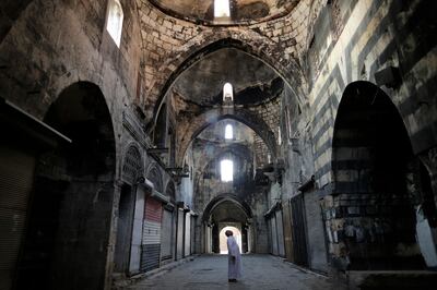 In this Saturday, July 27, 2019 photo, a Syrian man checks a market in the old city of Aleppo, Syria. Much of Aleppo's centuries-old covered market is still in ruins but slowly small parts of it have been renovated where business is slowly coming back to normal nearly three years after major battles in Syria's largest city and once commercial center came to an end. (AP Photo/Hassan Ammar)