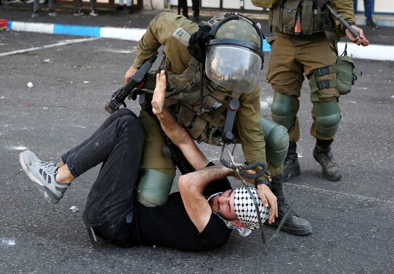 Israeli soldiers arrest a Palestinian man during clashes that broke out during a protest in the West Bank city of Hebron. EPA