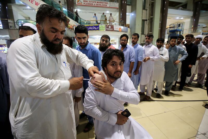 A health worker administers a dose of the Pak Vac vaccine. EPA