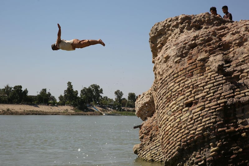 Iraqis jump into Tigris River in central Baghdad. All the pools have been closed because of Covid-19 pandemic as Iraq faces a heatwave. AFP