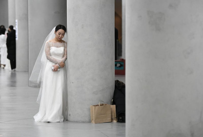 A bride leans on a pillar before a mass wedding ceremony organised by the Unification Church at Cheongshim Peace World Center in Gapyeong.  AFP
