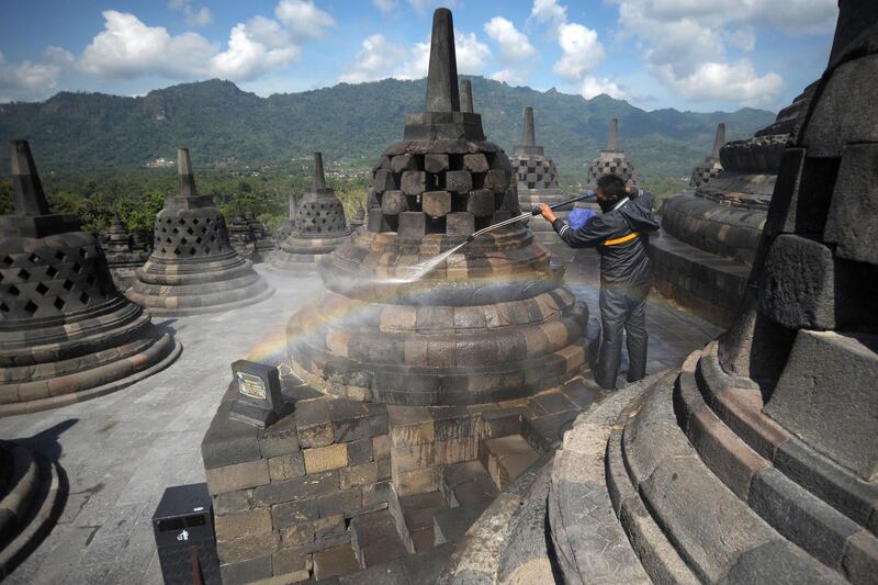 A worker cleans volcanic ash off the stupas at the Borobudur temple in Magelang Regency, a day after Mount Merapi erupted in Sleman, Indonesia.  AFP