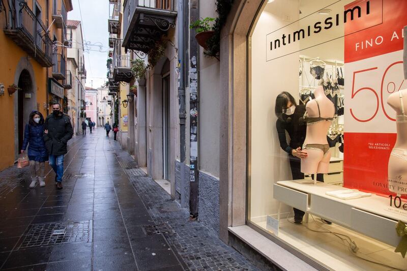 A staff worker arranges a store window during winter's sales in Basilicata, Potenza, Italy. EPA