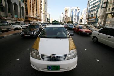 An old gold and white Abu Dhabi taxi. Andrew Parsons / The National