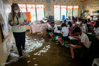 Teacher Mylene Ambrocio leads the class during the first day of in-person classes at a school flooded by the high tide in Macabebe in the Philippines' Pampanga province. Reuters