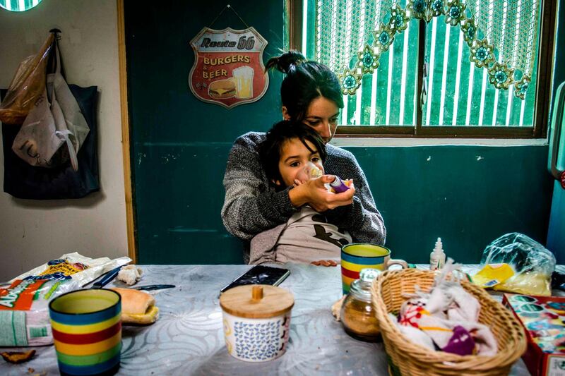 Chilean Isamar Carrasco, 27, helps one of her twins who suffers from asthma at her home in Santiago, April 18. Hans Scott / AFP