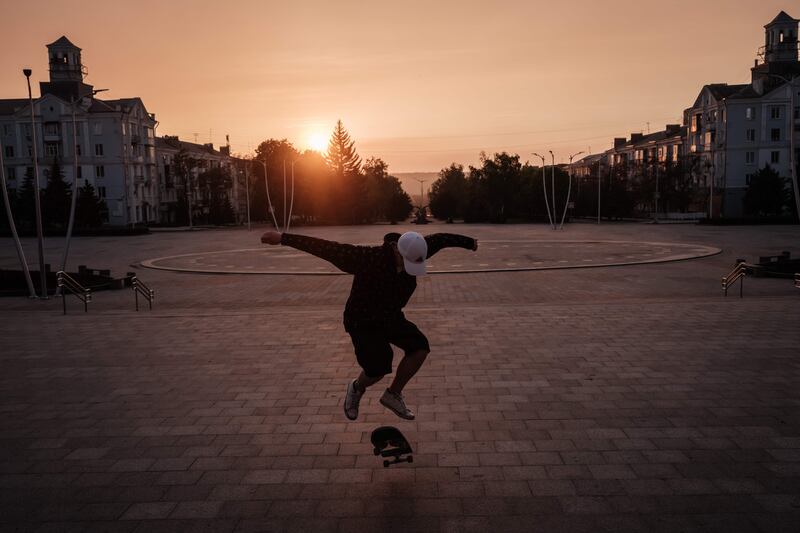 Roman Kovalenko, 18, practises skateboard tricks alone at sunset, at Peace Square in Kramatorsk, eastern Ukraine. His friends have fled the fighting. AFP