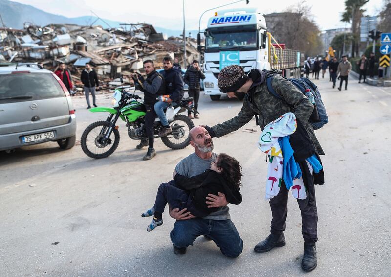 A man carries a girl who was rescued from the rubble of a collapsed building in Hatay, Turkey, after Monday’s earthquake. EPA