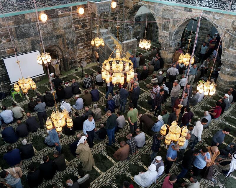 Worshippers are seen at the Al-Basha mosque, renovated and reopened after being destroyed during the war in Mosul, ahead of the holy month of Ramadan, in the old city of Mosul, Iraq.  Reuters