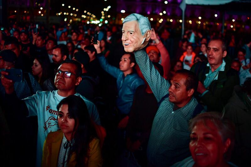 Supporters of the presidential candidate for the "Juntos haremos historia" coalition, Andres Manuel Lopez Obrador, celebrate at the Zocalo square in Mexico City, after getting the preliminary results of the general elections on July 1, 2018.  Anti-establishment leftist Andres Manuel Lopez Obrador won Mexico's presidential election Sunday by a large margin, according to exit polls, in a landmark break with the parties that have governed for nearly a century. Ronaldo Schemidt / AFP