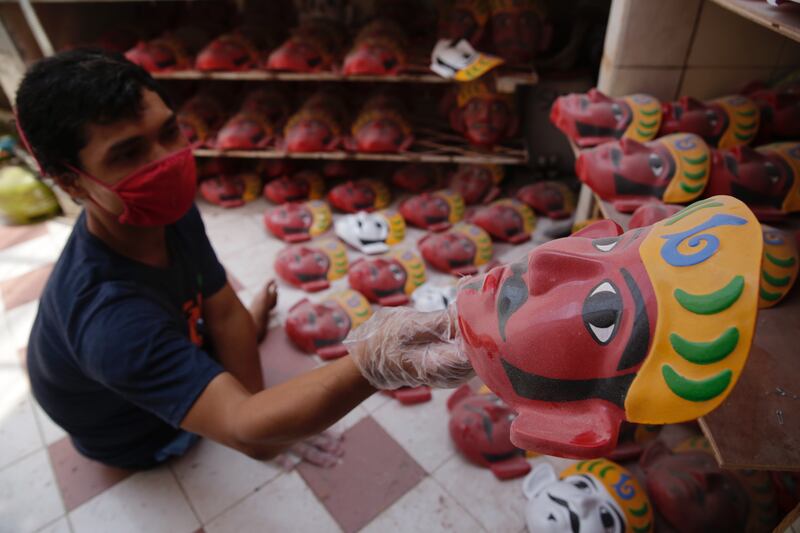 A worker arranges Ondel-ondel masks at a shop in Jakarta. Indonesia has started to loosen Covid-19 restrictions.  EPA