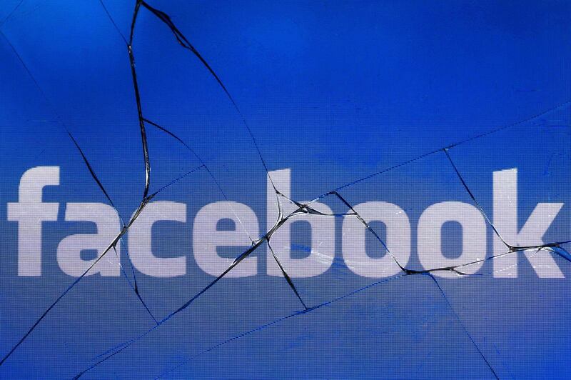 A picture taken in Paris on May 16, 2018 shows the logo of the social network Facebook on a broken screen of a mobile phone.  / AFP / JOEL SAGET
