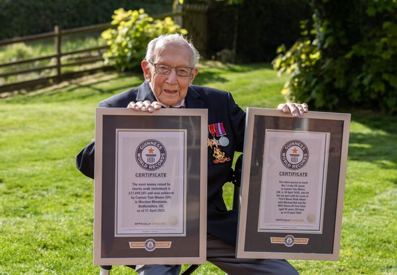 A handout picture released by Guinness World Records on April 24, 2020 shows World War II veteran Captain Tom Moore, 99, posing with his two certificates after he broke the record for the most money raised by charity walk (individual) with his effort to raise over 27 million GBP for the NHS and at the age of 99 years 359 days became the oldest person to reach number one in the UK charts after teaming up with British singer Michael Ball to release a cover of 'You’ll never walk alone'.  RESTRICTED TO EDITORIAL USE - MANDATORY CREDIT "AFP PHOTO / GUINNESS WORLD RECORDS / EMMA SOHL" - NO MARKETING - NO ADVERTISING CAMPAIGNS - RESTRICTED FOR USE TO ILLUSTRATE THE FACTS, PEOPLE OR THINGS MENTION IN THE CAPTION - RESTRICTED TO SUBSCRIPTION USE - NO RESALE - NO ARCHIVE - DISTRIBUTED AS A SERVICE TO CLIENTS
 / AFP / GUINNESS WORLD RECORDS / Emma SOHL / RESTRICTED TO EDITORIAL USE - MANDATORY CREDIT "AFP PHOTO / GUINNESS WORLD RECORDS / EMMA SOHL" - NO MARKETING - NO ADVERTISING CAMPAIGNS - RESTRICTED FOR USE TO ILLUSTRATE THE FACTS, PEOPLE OR THINGS MENTION IN THE CAPTION - RESTRICTED TO SUBSCRIPTION USE - NO RESALE - NO ARCHIVE - DISTRIBUTED AS A SERVICE TO CLIENTS
