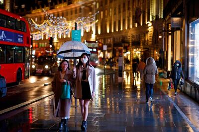 Shoppers and pedestrians pass under the Christmas lights on Regents Street in central London on December 14, 2020, as it is announced that Greater London will be moved into Tier 3 from Tier 2 from Wednesday December 16. London is to move into the highest level of anti-virus restrictions, the health minister announced Monday. The British capital from Wednesday will go into "tier three" restrictions, which force the closure of theatres and ban people from eating out at restaurants or drinking in pubs, the Health Secretary Matt Hancock told parliament.
 / AFP / Tolga Akmen
