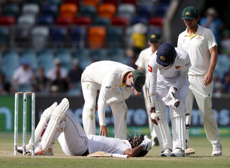 epa07337549 Australia's Nathan Lyon looks down at Sri Lanka's Dimuth Karunaratne as he lies ont he ground after being struck by a delivery by Australia's Pat Cummins during day two of the second Test match between Australia and Sri Lanka at Manuka Oval in Canberra, Australian Capital Territory, Australia, 02 February 2019.  EPA/DAVID GRAY -- IMAGES TO BE USED FOR NEWS REPORTING PURPOSES ONLY, NO COMMERCIAL USE WHATSOEVER, NO USE IN BOOKS WITHOUT PRIOR WRITTEN CONSENT FROM AAP -- AUSTRALIA AND NEW ZEALAND OUT