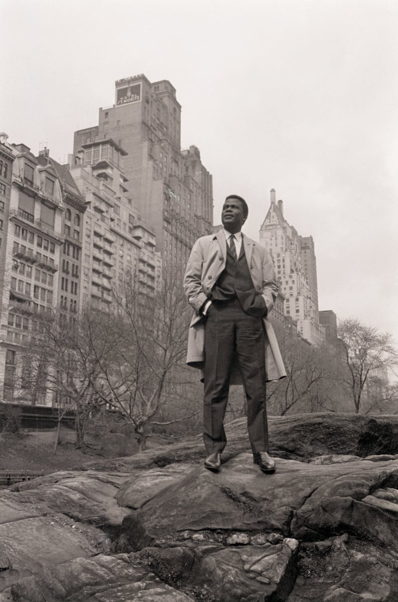 Sidney Poitier poses against a background of New York apartment buildings in Central Park in 1964. Getty Images