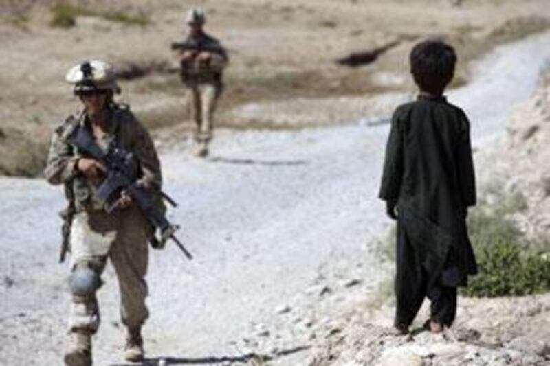 An Afghan boy watches as US marines patrol in Nawa district, Helmand province, southern Afghanistan.
