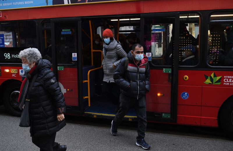 Masked travellers get off a bus in London.  According to his official spokesperson in Downing Street, Mr Johnson has told his cabinet that the Omicron variant of coronavirus appears to be more transmissible. EPA