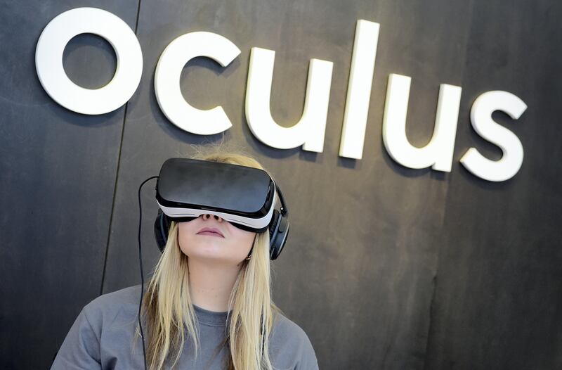 A woman use an "Oculus VR" virtual reality device during a press preview of the "Facebook Innovation Hub" in Berlin on February 24, 2016. / AFP PHOTO / TOBIAS SCHWARZ