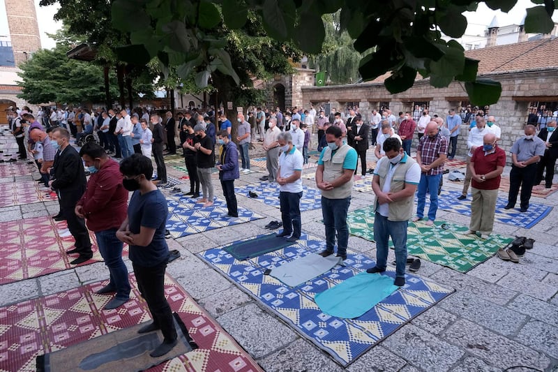 Worshippers wearing masks to help stop the spread of the coronavirus, offer Eid al-Adha prayer while maintaining a social distance in front of the Gazi Husrev-beg mosque in Sarajevo, Bosnia, Friday, July 31, 2020. Eid al-Adha, or Feast of Sacrifice, Islam's most important holiday, marks the willingness of the Prophet Ibrahim to sacrifice his son. (AP Photo/Kemal Softic)