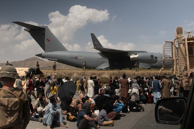 People wait as UK armed forces take part in the evacuation of personnel from Kabul Airport in Afghanistan. PA