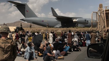 People wait as UK armed forces take part in the evacuation of personnel from Kabul Airport in Afghanistan. PA