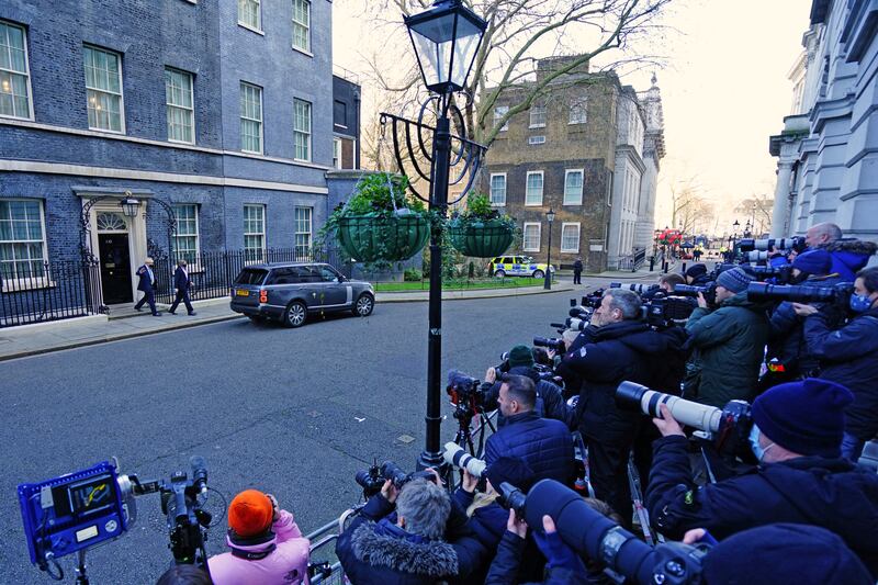 Members of the media photograph Prime Minister Boris Johnson, left, as he leaves 10 Downing Street, London, to attend Prime Minister's Questions at the Houses of Parliament. AP Photo