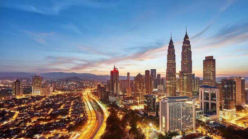A 16x9 view of beautiful sunrise overlooking national landmark of Malaysia, The Petronas Twin Towers.