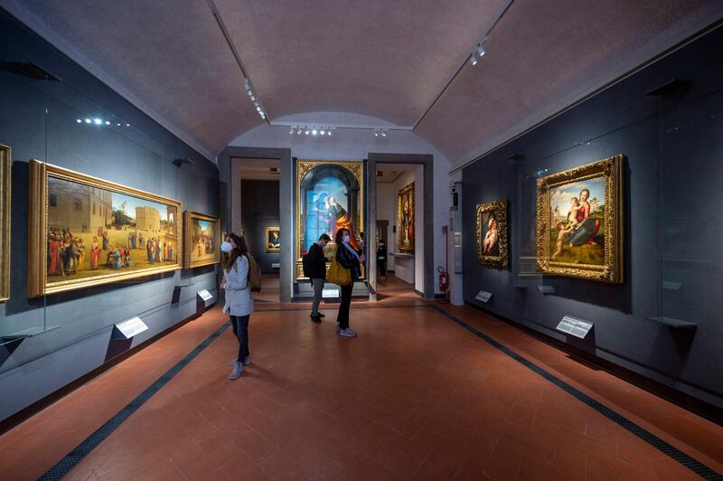 Visitors look at paintings exhibited at the Uffizi Galleries in Florence, Italy. EPA