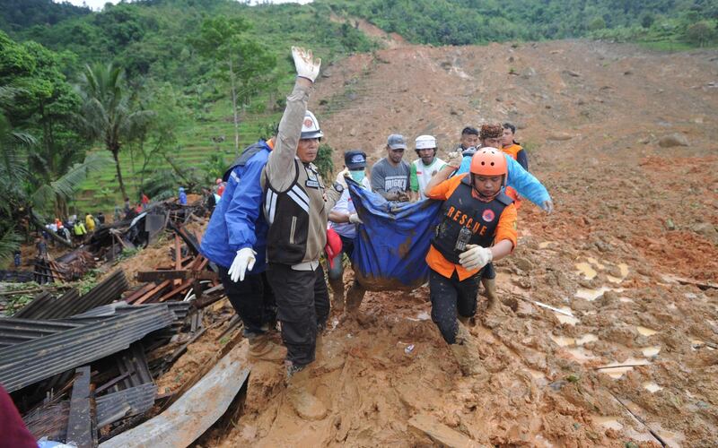 Indonesian rescuers carry the remains of a landslide victim at Sirnaresmi village in Sukabumi, Indonesia.  EPA