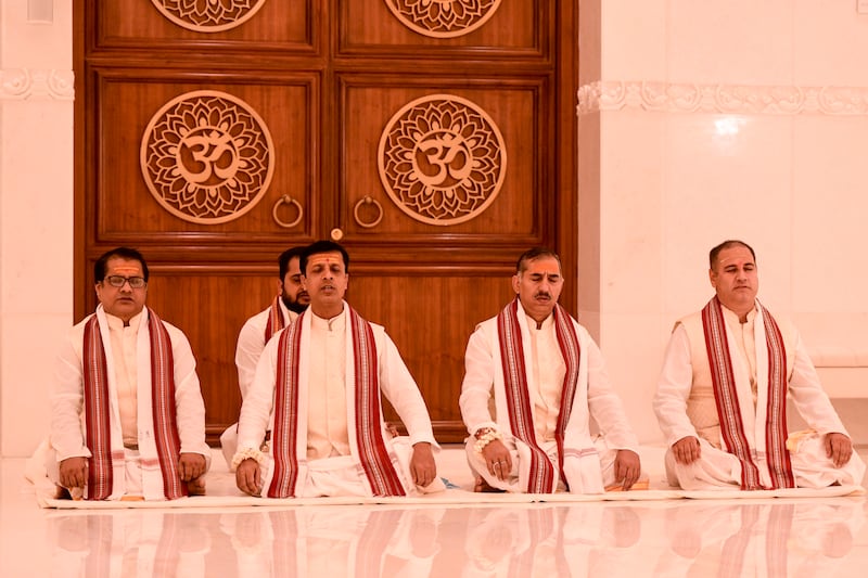 Hindu priests chant prayers in the main prayer hall.