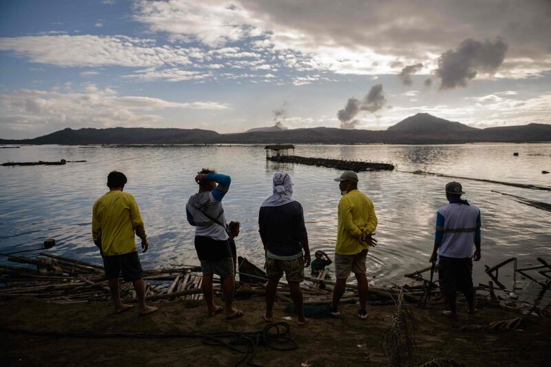 Fishermen make repairs to their operations affected by the ash-fall from the eruption of the Taal volcano, in Buso Buso on January 20. The incident has led to decimated fish, scarred coffee plants and vanished tourists: Ed Jones / AFP