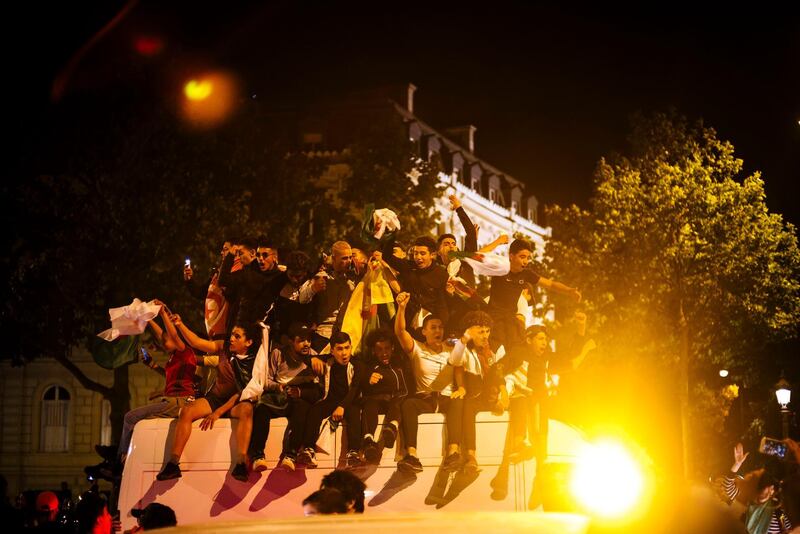 People celebrate on a car on the Champs Elysees after the African Cup of Nations semifinal soccer match between Algeria and Nigeria in Paris, France, Sunday, July 14, 2019. Algeria won 2-1. (AP Photo/Kamil Zihnioglu)