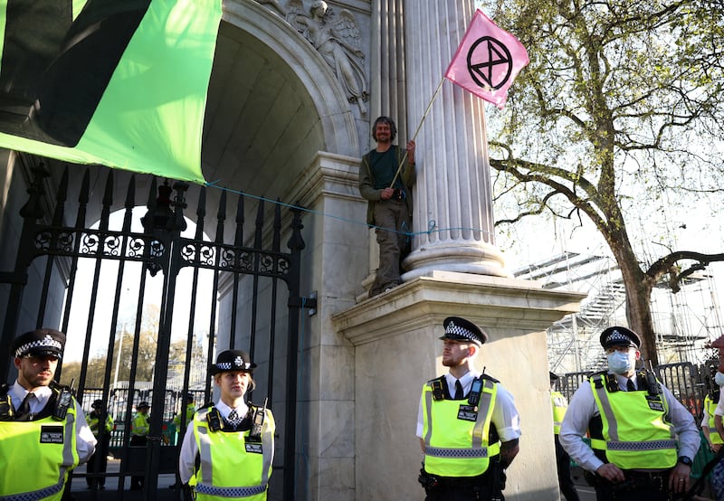 Activist Daniel Hooper, also known as ‘Swampy’, stands on Marble Arch after draping a banner, as part of an Extinction Rebellion protest in central London. Reuters