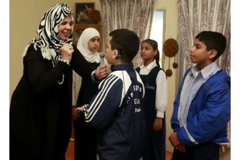 Awatef Ebrahim el Zamek communicates with pupils during a lesson on body movement at the Al Amal school for the Deaf. Satish Kumar / The National