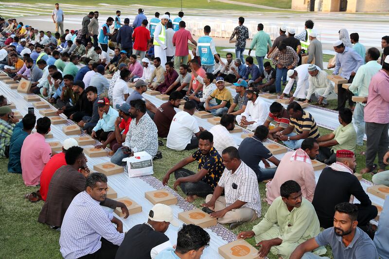 Workers gather to break their fast with free iftar meals.  Pawan Singh / The National